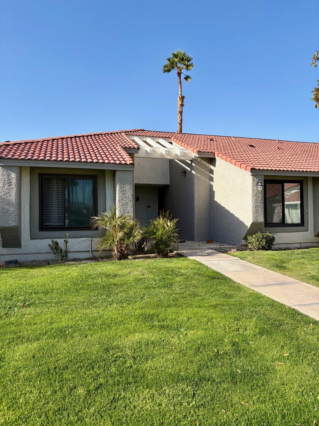 43376 Cook Street, Unit 32 Palm Desert, CA 92211 - Photo 3 of 31 a front view of a house with swimming pool garden and outdoor seating