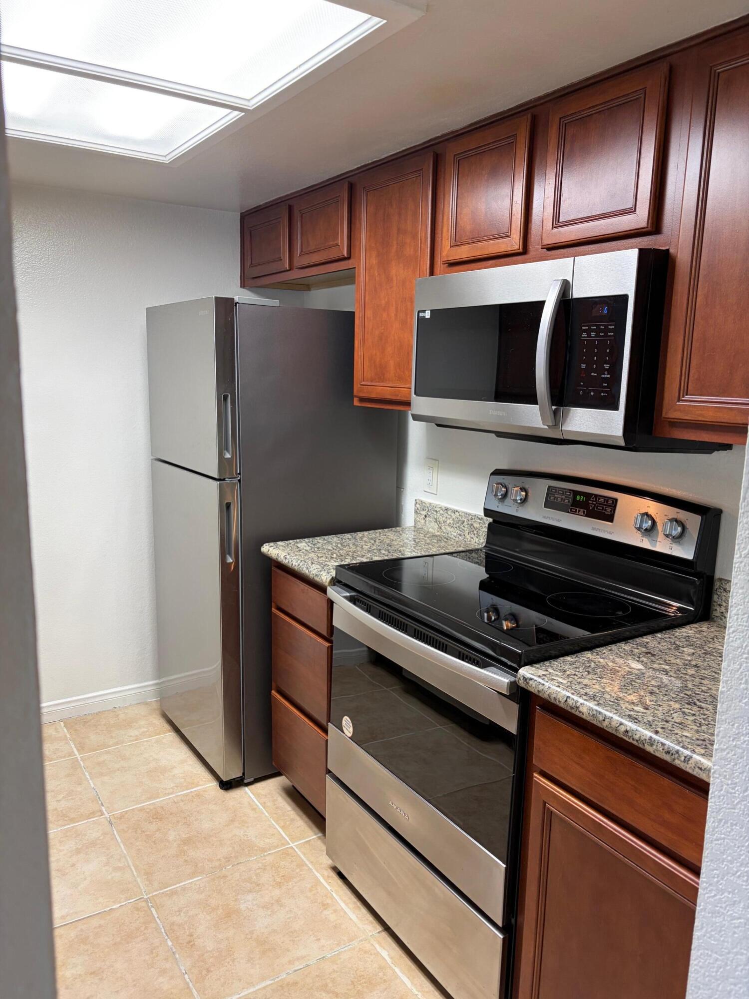 43376 Cook Street, Unit 32 Palm Desert, CA 92211 - Photo 6 of 31 a kitchen with wooden cabinets and stainless steel appliances