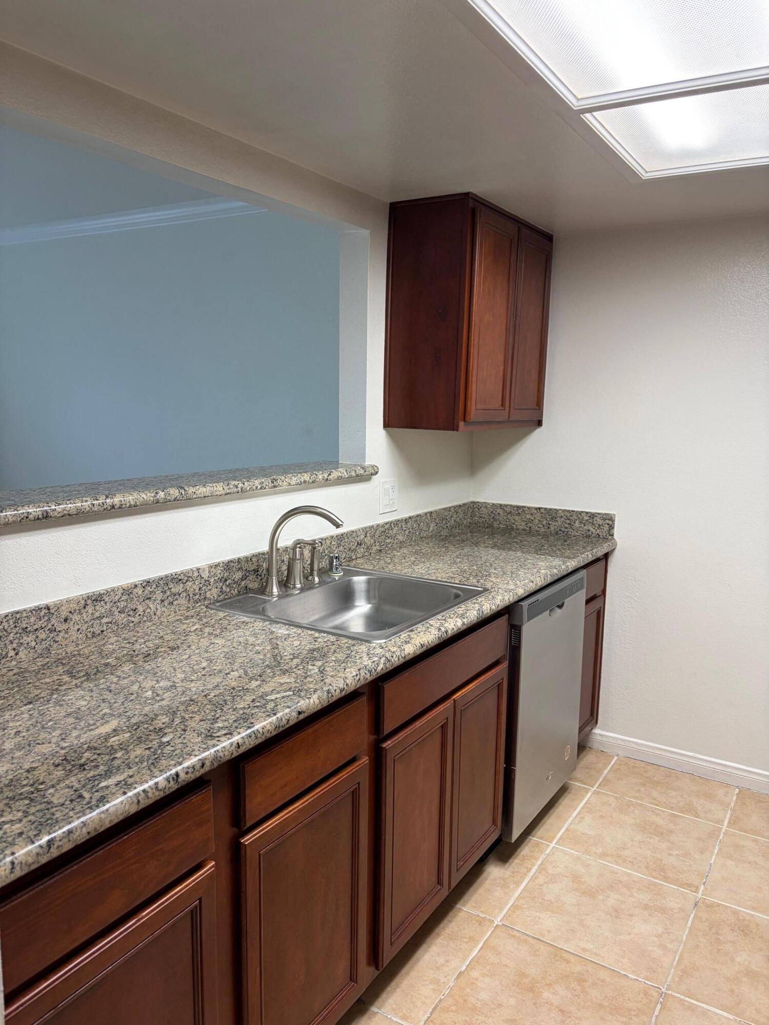 43376 Cook Street, Unit 32 Palm Desert, CA 92211 - Photo 7 of 31 a kitchen with granite countertop a sink and wooden cabinets