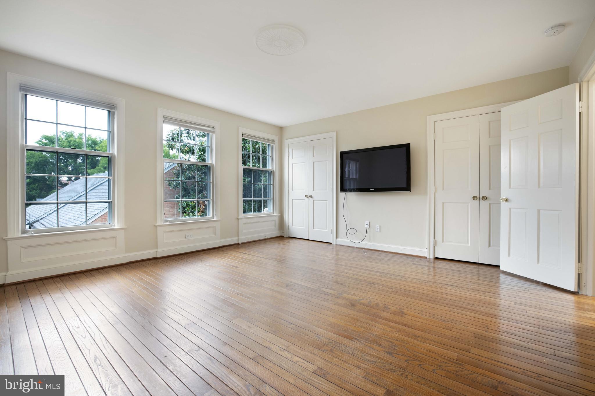3327 R Street Northwest Washington, DC 20007 - Photo 18 of 39 an empty room with wooden floor and windows
