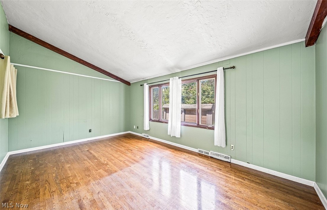 4069 Bushnell Road Cleveland, OH 44121 - Photo 11 of 39 Empty room with wood walls and light wood-style flooring