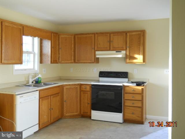 7608 Bethel Road Willards, MD 21874 - Photo 2 of 10 a kitchen with a stove sink and cabinets