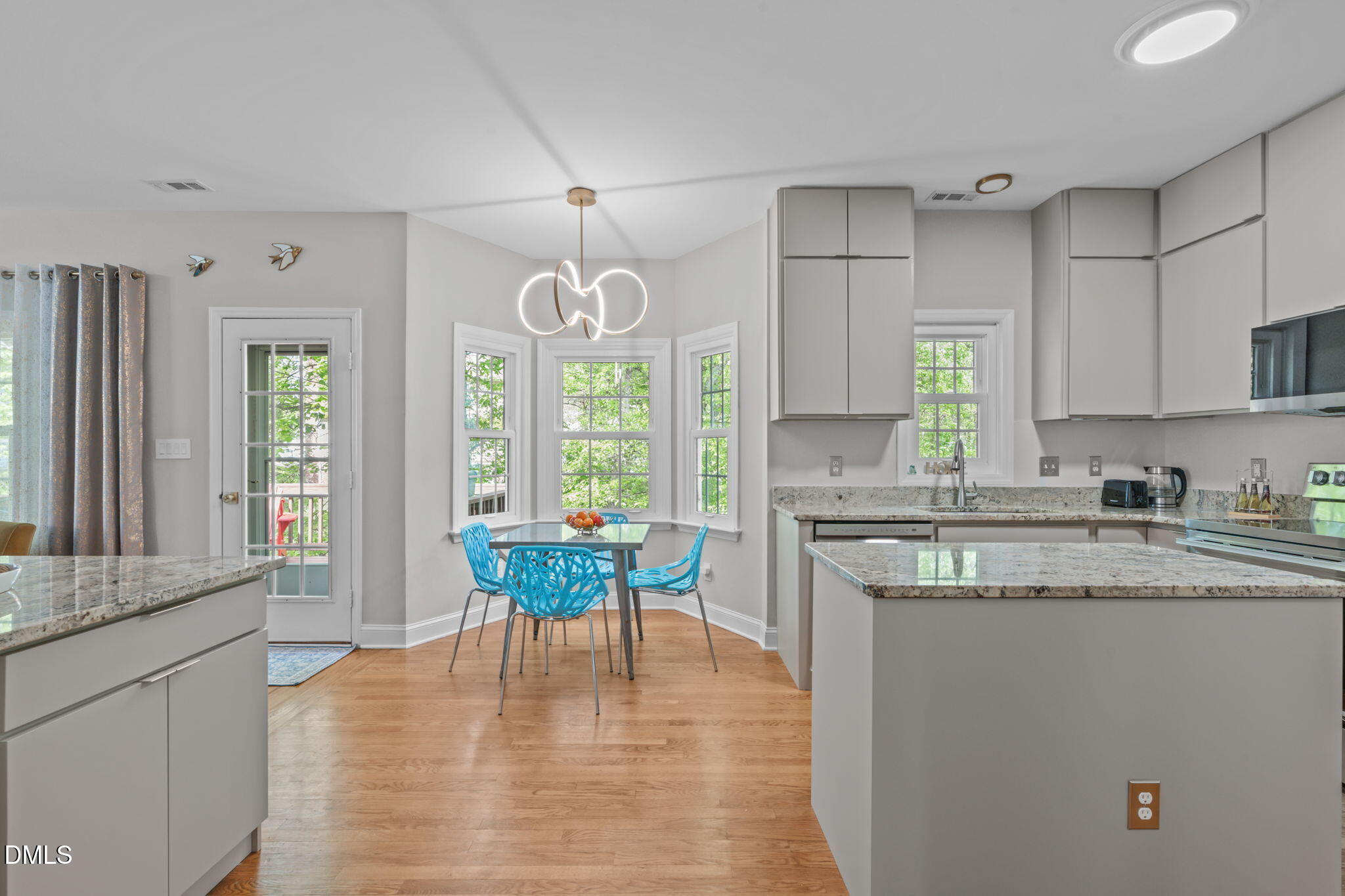 104 Lost Tree Lane Cary, NC 27513 - Photo 3 of 54 a kitchen with stainless steel appliances granite countertop a stove a sink dishwasher a microwave oven and a dining table with wooden floor