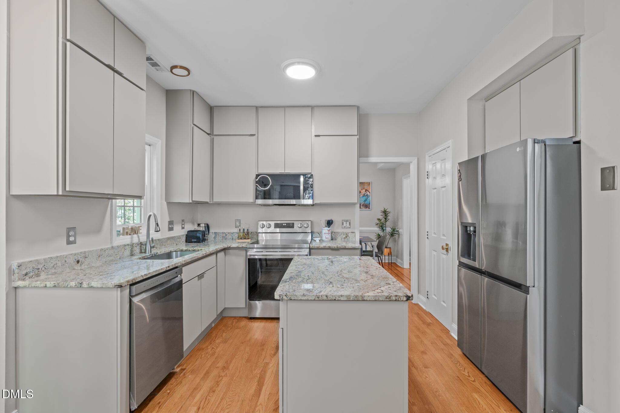 104 Lost Tree Lane Cary, NC 27513 - Photo 4 of 54 a kitchen with a sink a refrigerator and white cabinets