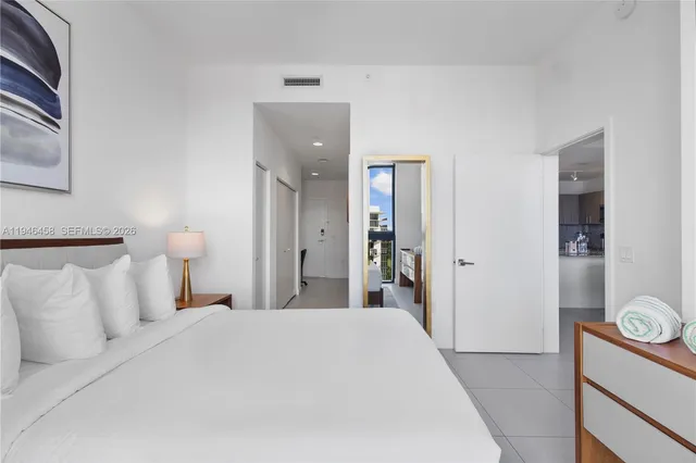 a bedroom with a bed and painting on the wall