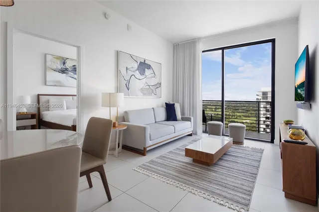 a living room with furniture a flat screen tv and a floor to ceiling window