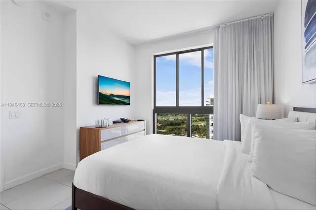 a bedroom with a bed and a flat screen tv