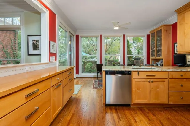 a view of a kitchen with kitchen island wooden floors and stainless steel appliances