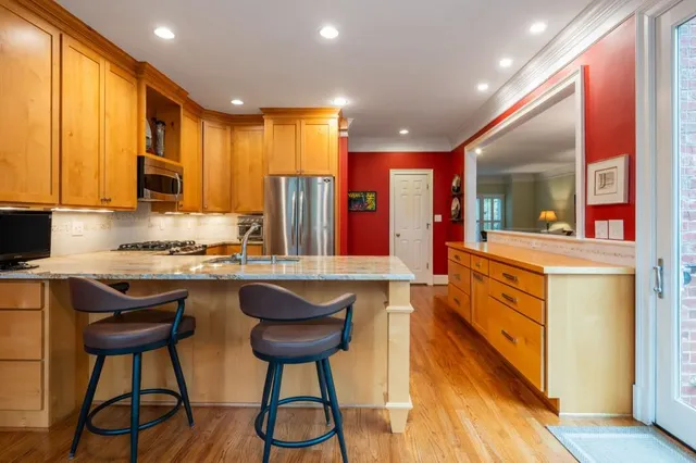 a kitchen with stainless steel appliances granite countertop a stove a sink and a refrigerator