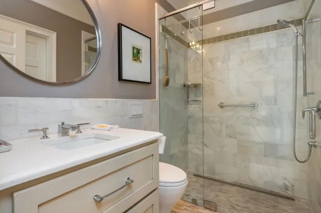 a bathroom with a sink a toilet and shower