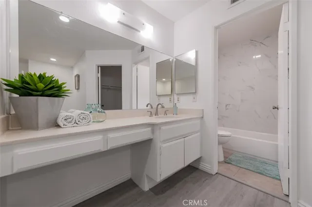 a bathroom with a granite countertop sink a large mirror and a bathtub