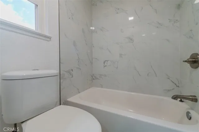 a bathroom with a toilet and a bathtub