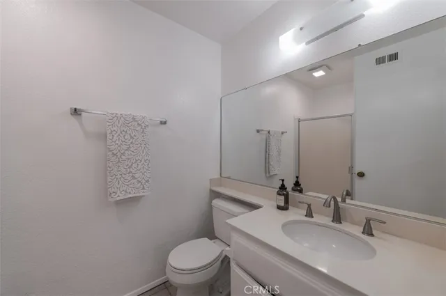 a bathroom with a toilet sink a mirror and vanity