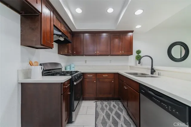 a kitchen with stainless steel appliances granite countertop a sink stove and cabinets