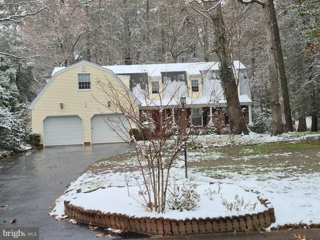 a front view of a house with a garden and trees