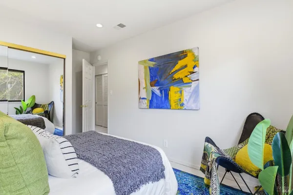 a bedroom with a bed and painting on the wall