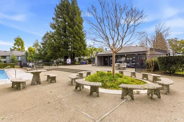 a view of a patio with couches table and chairs and potted plants