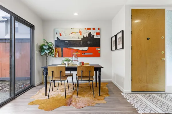 a view of a dining room with furniture a rug and wooden floor