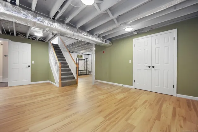 a view of empty room with wooden floor and stairs