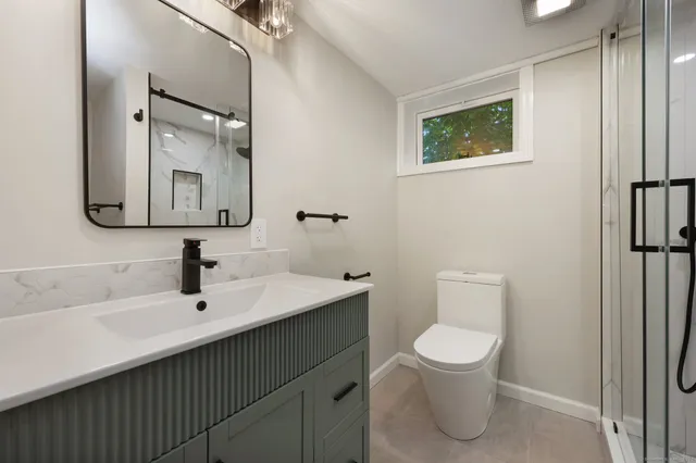 a bathroom with a toilet sink and mirror