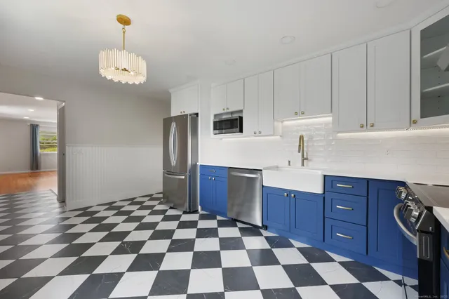 a kitchen with stainless steel appliances granite countertop a refrigerator and a cabinets