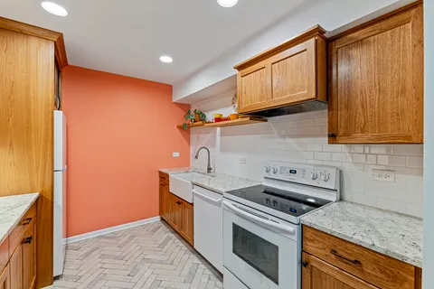 a kitchen with stainless steel appliances granite countertop a stove a sink and a refrigerator