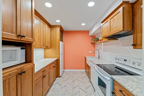 a kitchen with stainless steel appliances granite countertop a sink a stove and a refrigerator