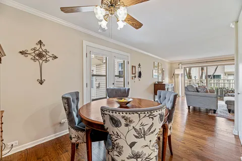 a dining room with furniture a chandelier and wooden floor