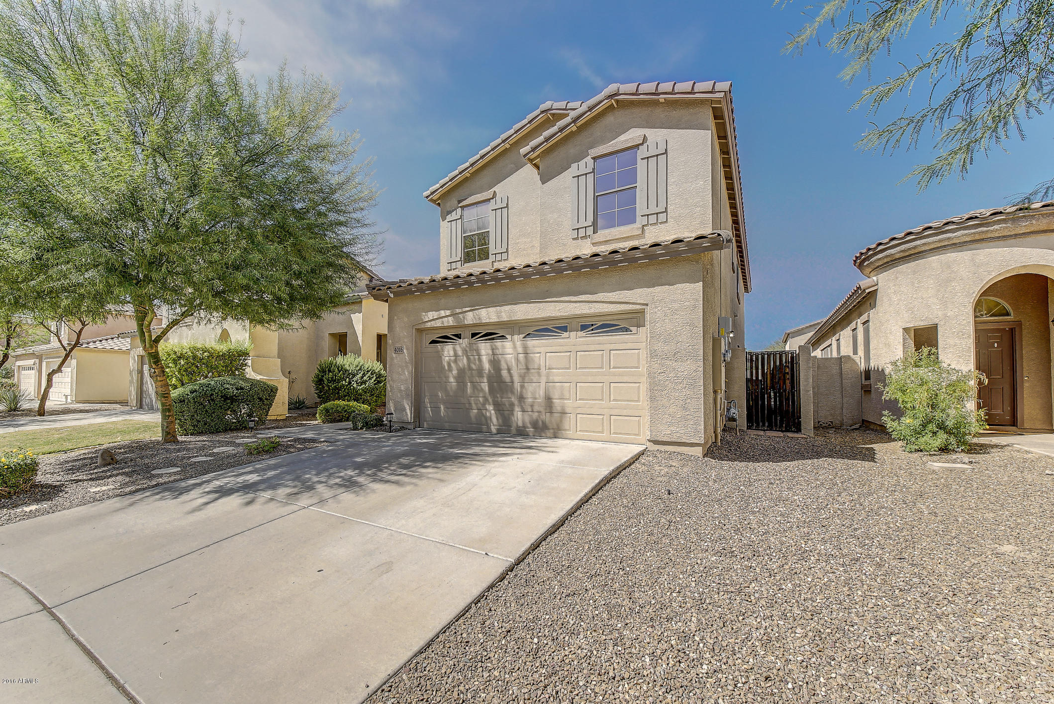 4016 East Ironhorse Road Gilbert, AZ 85297 - Photo 2 of 48 a front view of a house with a yard and garage