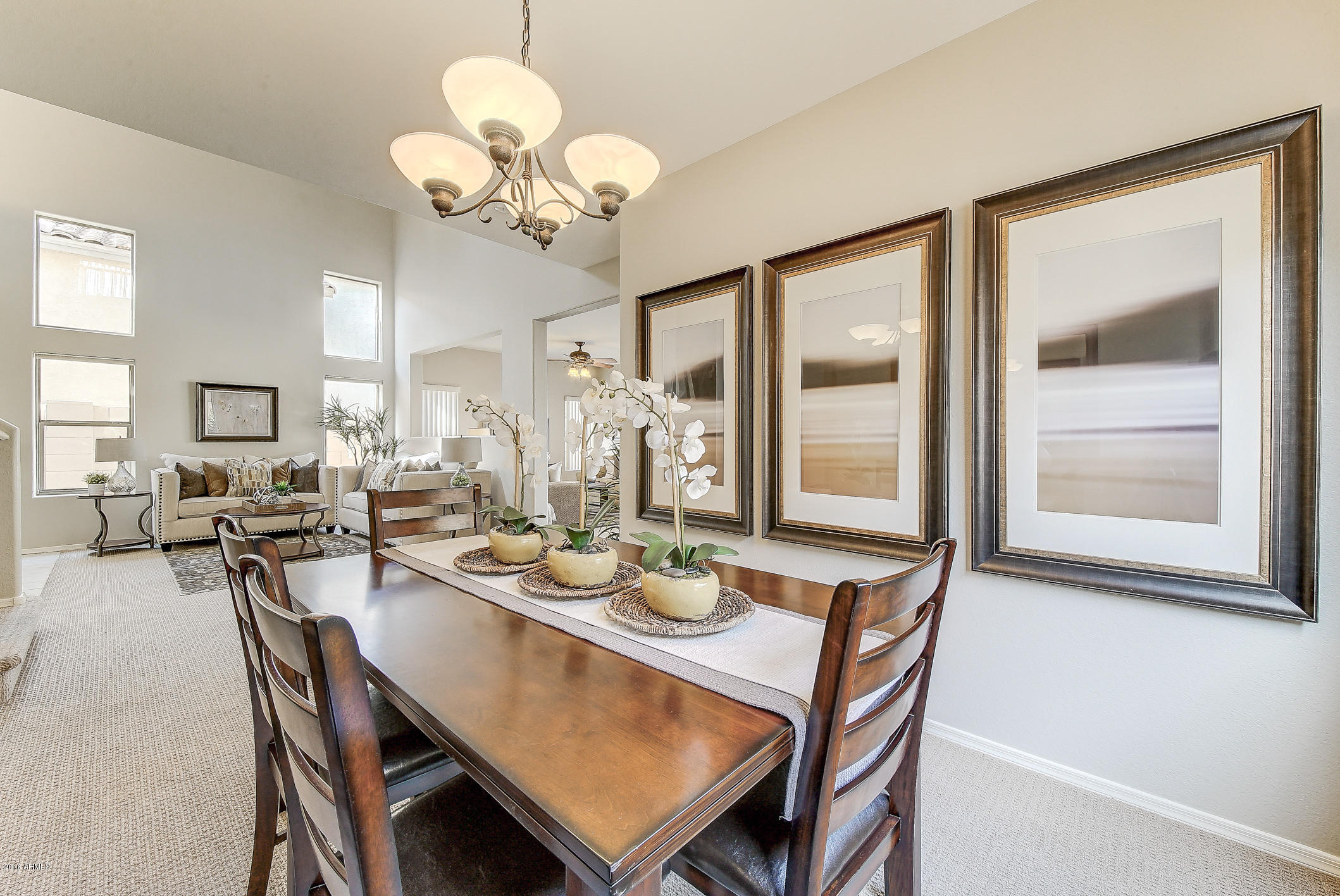4016 East Ironhorse Road Gilbert, AZ 85297 - Photo 9 of 48 a dining room with wooden floor a chandelier a wooden table and chairs