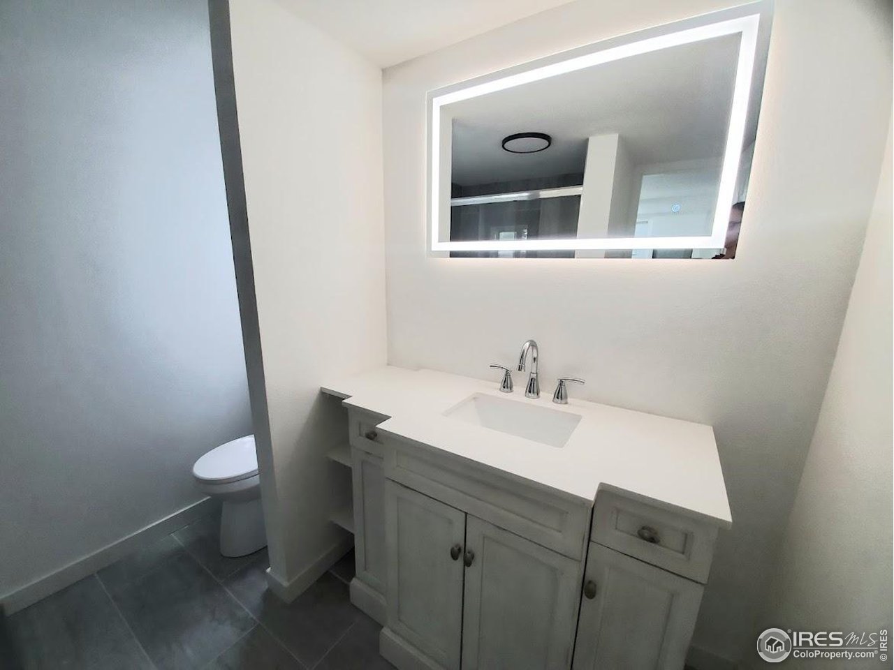 1212 Butte Road, Unit 7 Loveland, CO 80537 - Photo 13 of 21 a bathroom with a toilet sink and mirror