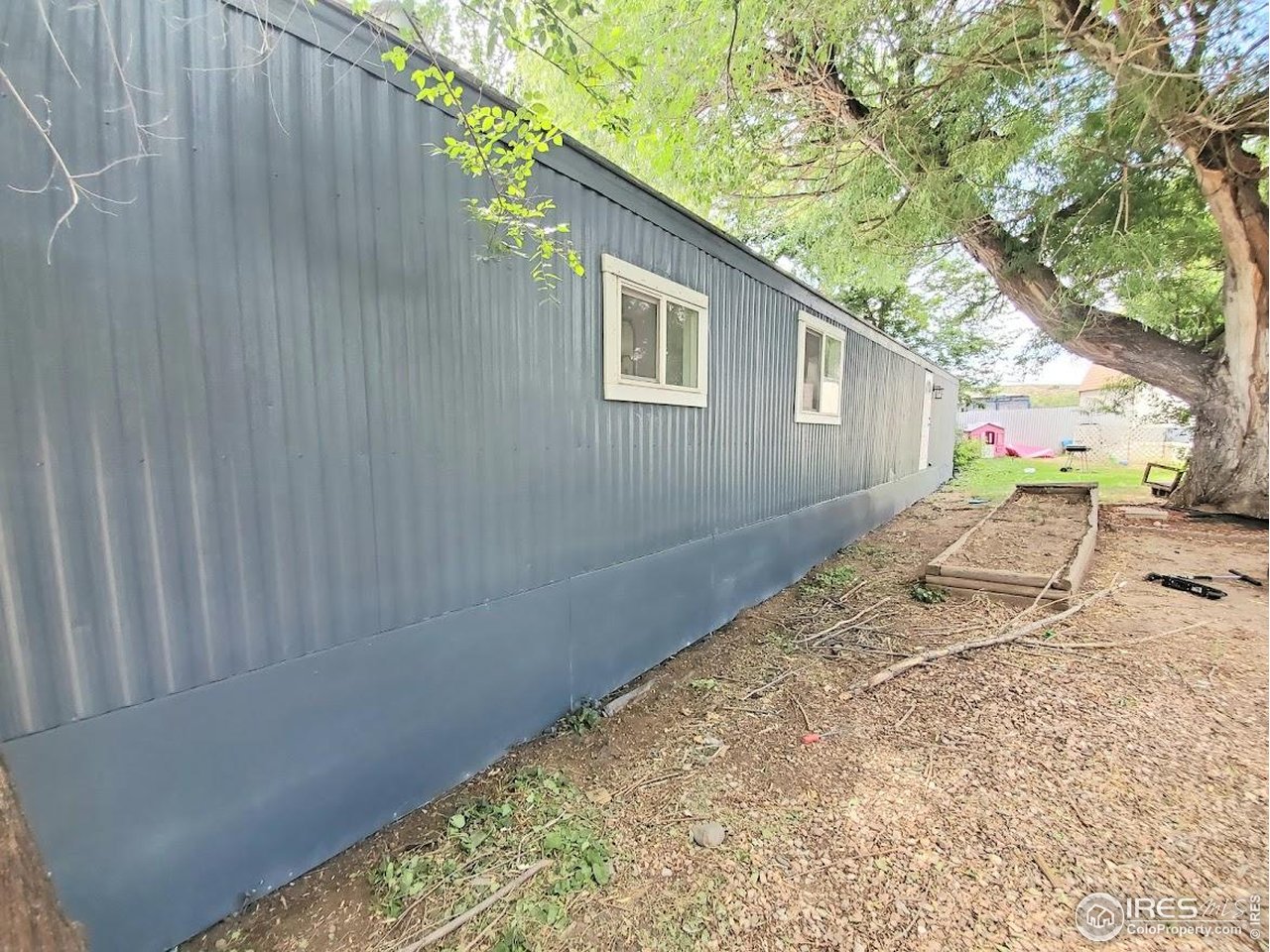 1212 Butte Road, Unit 7 Loveland, CO 80537 - Photo 20 of 21 a backyard of a house with large trees and wooden fence