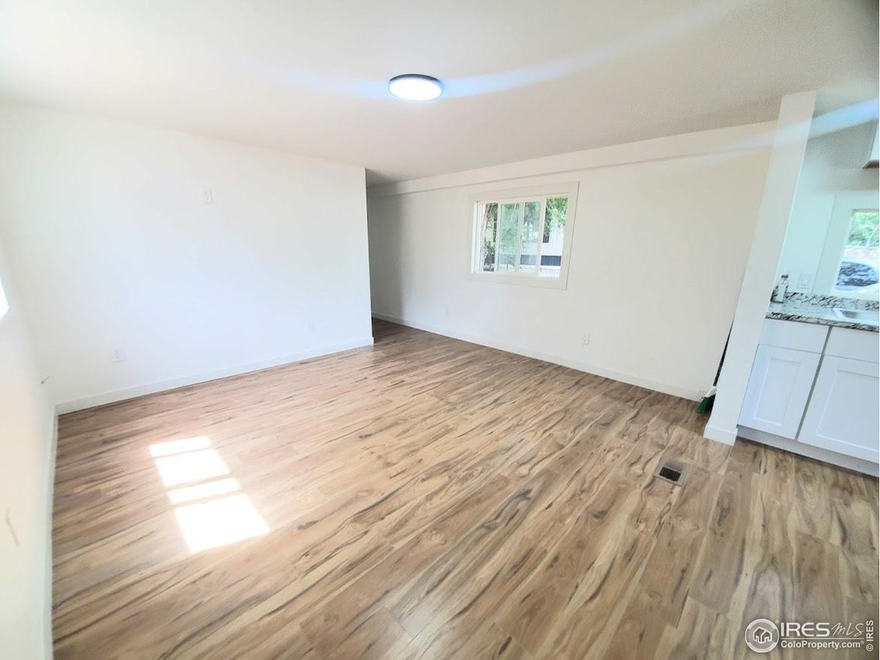 1212 Butte Road, Unit 7 Loveland, CO 80537 - Photo 2 of 21 an empty room with wooden floor and windows