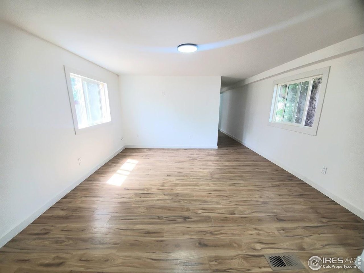 1212 Butte Road, Unit 7 Loveland, CO 80537 - Photo 3 of 21 a view of an empty room with wooden floor and a window
