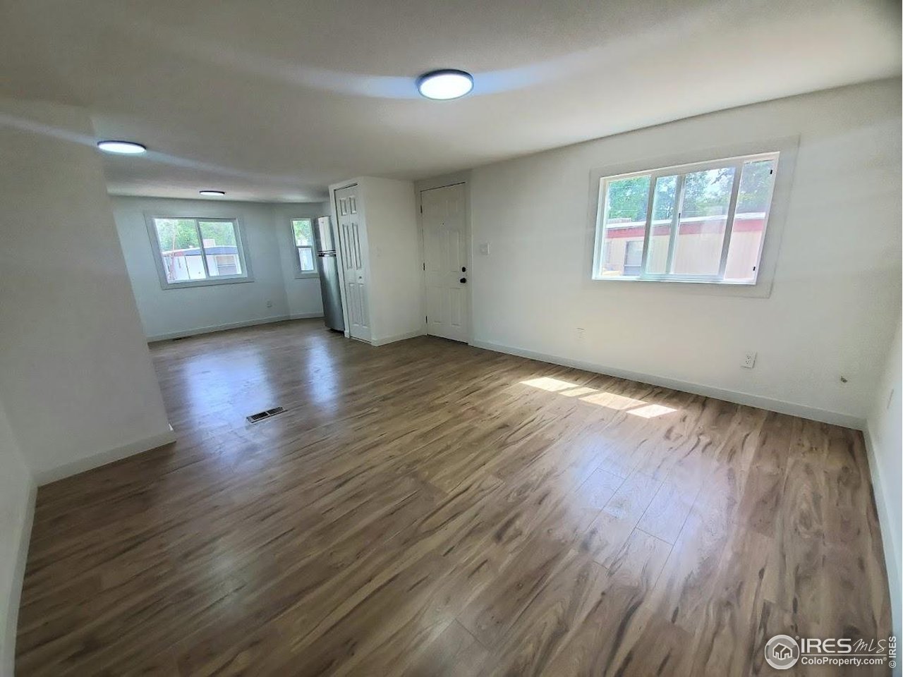 1212 Butte Road, Unit 7 Loveland, CO 80537 - Photo 4 of 21 an empty room with wooden floor and windows