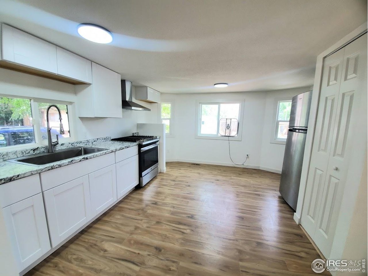 1212 Butte Road, Unit 7 Loveland, CO 80537 - Photo 6 of 21 a large kitchen with stainless steel appliances granite countertop a lot of counter space and wooden floors
