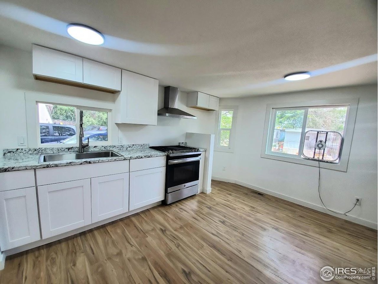 1212 Butte Road, Unit 7 Loveland, CO 80537 - Photo 7 of 21 a kitchen with stainless steel appliances granite countertop a stove a sink and a refrigerator