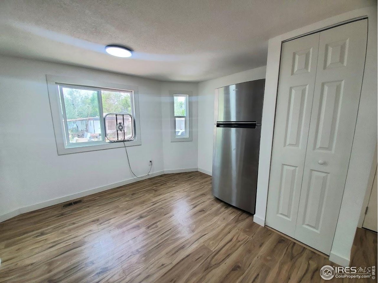 1212 Butte Road, Unit 7 Loveland, CO 80537 - Photo 9 of 21 an empty room with wooden floor and windows