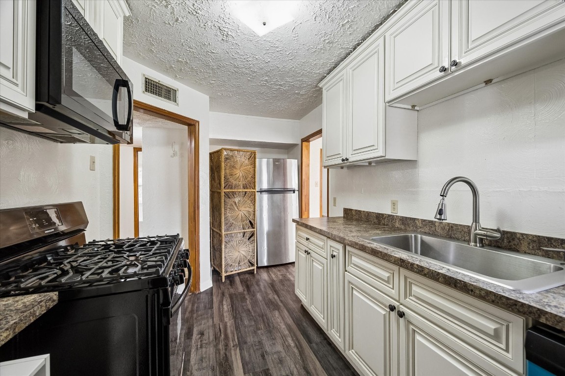 2308 McClendon Street, Unit 1 Houston, TX 77030 - Photo 6 of 15 Stainless steel refrigerator. Water heater is located next to the refrigerator behind a decorative screen.