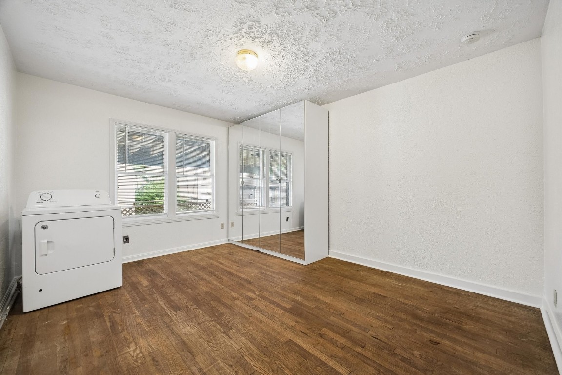 2308 McClendon Street, Unit 1 Houston, TX 77030 - Photo 10 of 15 The property's second rear bedroom overlooking the backyard. Mirrored wardrobe stays with the property. Dryer also remains with the unit.