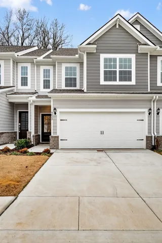 a front view of a house with a yard and a garage