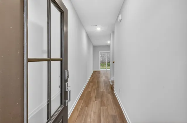 a view of a hallway with wooden floor and staircase