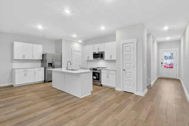 a view of kitchen with wooden floor and electronic appliances