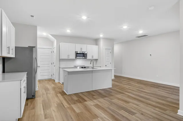 a kitchen with stainless steel appliances refrigerator sink and cabinets
