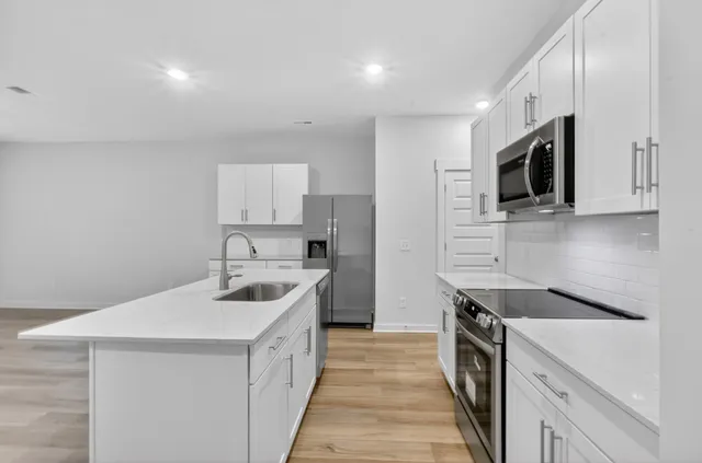 a kitchen with a sink stove and microwave