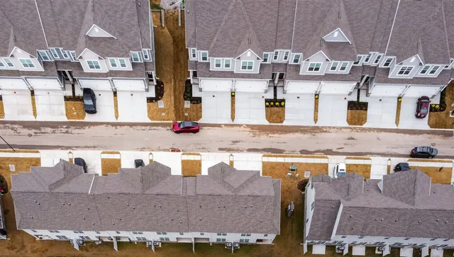an aerial view of residential houses with outdoor space and swimming pool