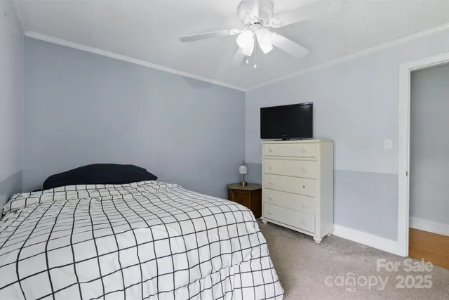 a bedroom with a bed and a flat tv screen on dresser