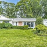 a front view of a house with a yard and trees