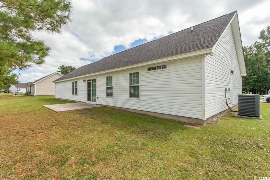 125 St Barnabus Road Loris, SC 29569 - Photo 6 of 39 Back of house with central AC unit, a yard, and a