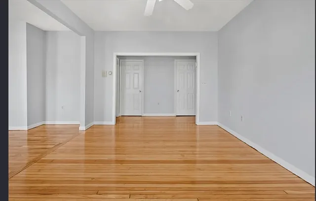 a view of an empty room with wooden floor